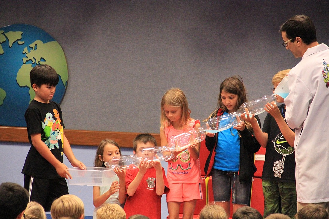 Local children learn how an aqueduct works.