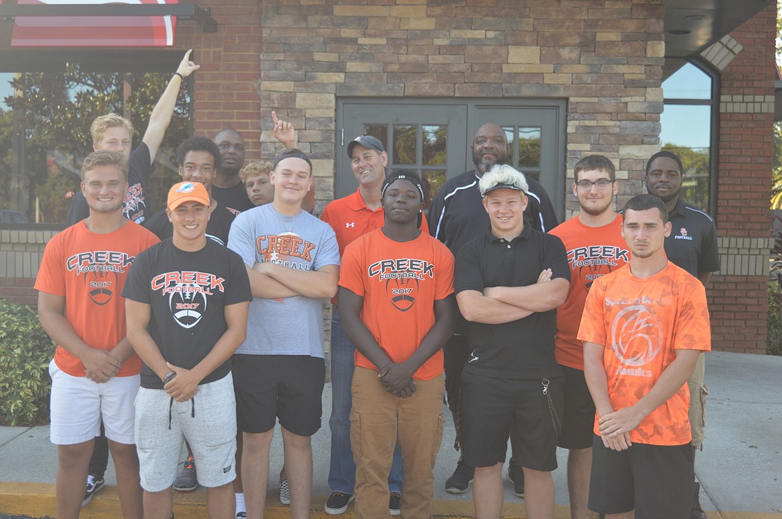 The Spruce Creek football team takes a team photo outside of Applebee's during the team's flapjack fundraiser on July 22.
