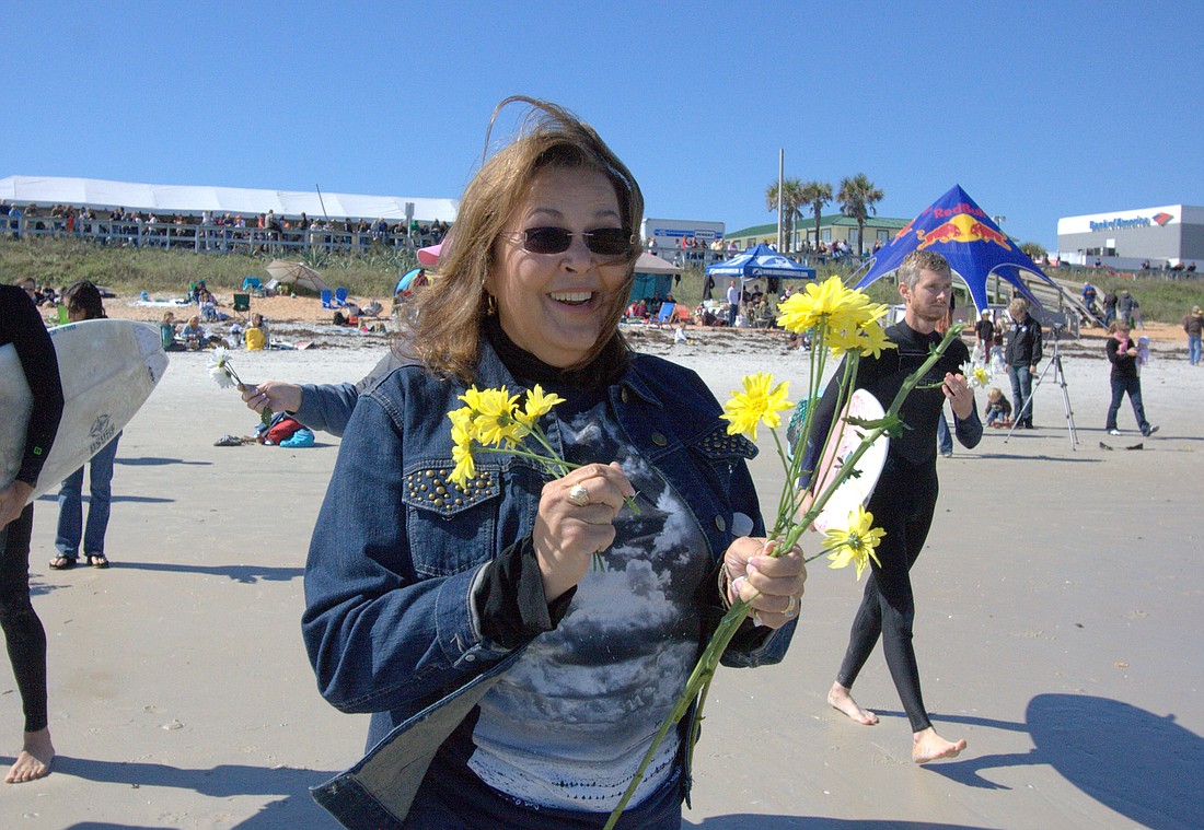 Barbara Tant hands out flowers before the paddle out at the November 2010 contest. PHOTO BY SHANNA FORTIER