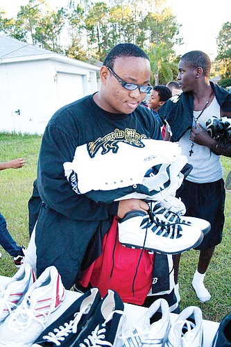 Hakeem Gibbs collects clothes and shoes donated by Mardy Gilyard.PHOTO BY SHANNA FORTIER