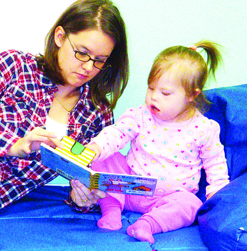 Donelle Evensen, lead teacher at Camp I Can, reads to the youngest student COURTESY PHOTO