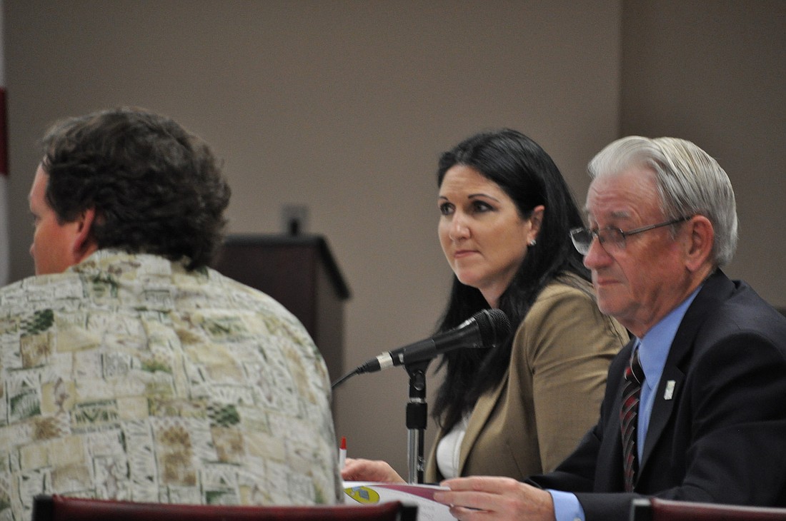County Commissioners Alan Peterson and Milissa Holland discuss Monday the possibility of using an iPad at future meetings in an attempt to save money and trees.