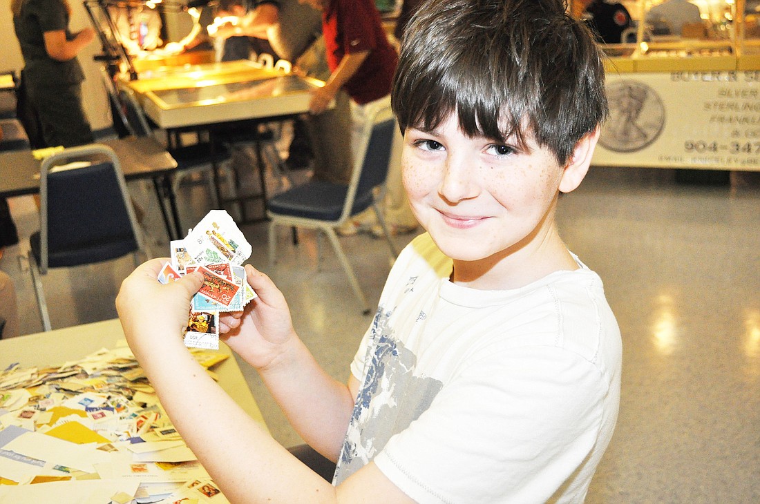 Caleb Krassner, 9, shows of the new stamps for his collection. PHOTOS BY SHANNA FORTIER