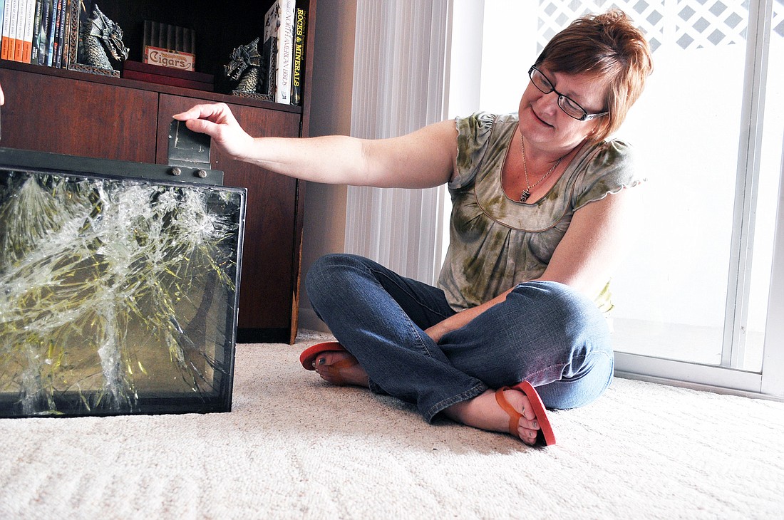 Memory Nichols holding a portion of the window from Corey's Humvee, which was hit by a roadside bomb Dec. 11, 2003, in Afghanistan.