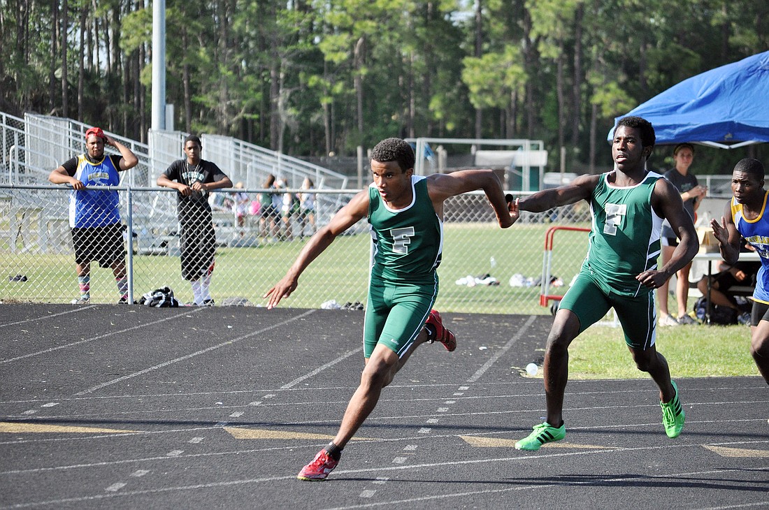 Chris Stubbs hands the baton to Turrel Mathews during the final leg of the preliminaries in the 4x100-meter relay. FPC took first place. PHOTOS BY SHANNA FORTIER