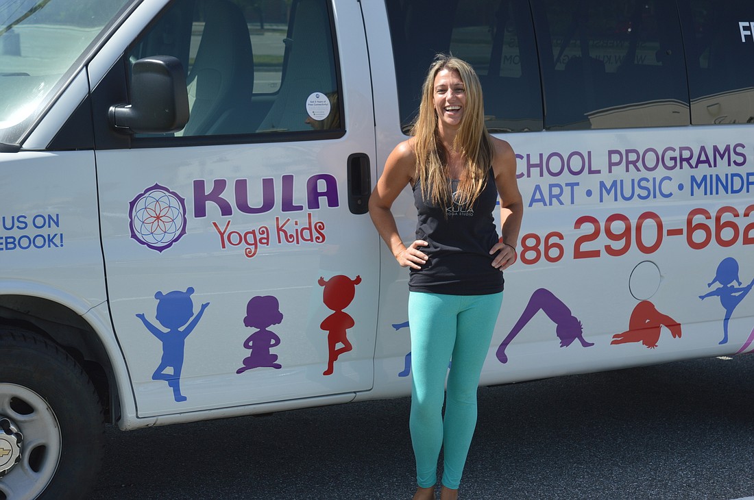 Michele Guess poses in front of the Kula Yoga Kids van. The van will pick up kids from local schools for an after-school yoga program starting on Aug. 14.