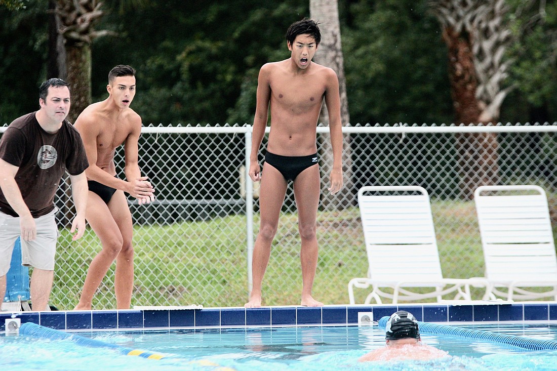 Atlantic swimmer Joseph Yim (middle) cheers on a teammate during a race. Photo by Ray Boone