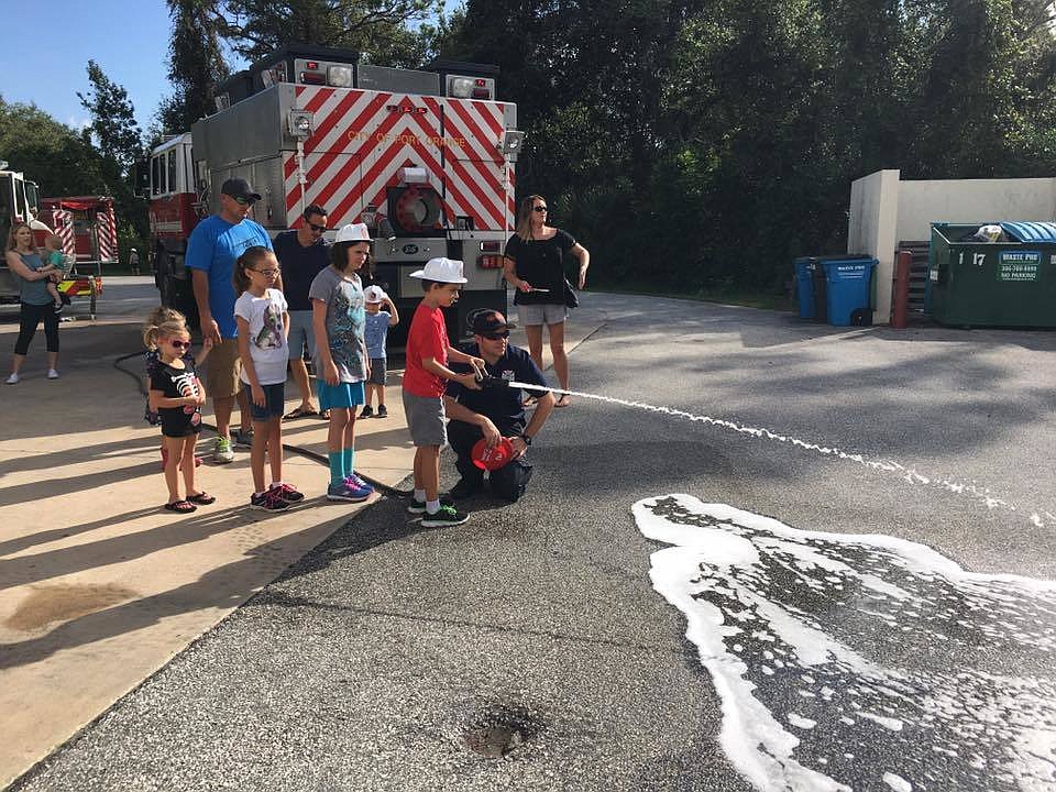 Children learn to use a fire hose during the open house. Photo courtesy of Port Orange Fire and Rescue