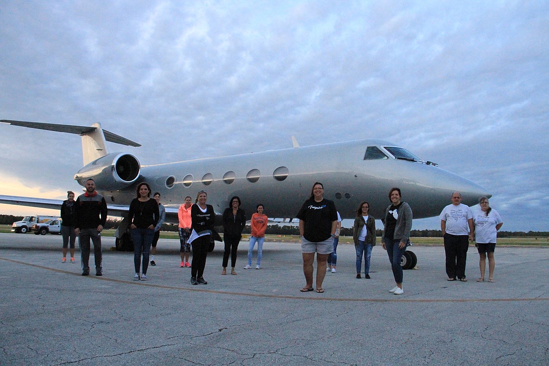 Volunteers stand in front of the aircraft that brought donated goods from California. Photo by Nichole Osinski