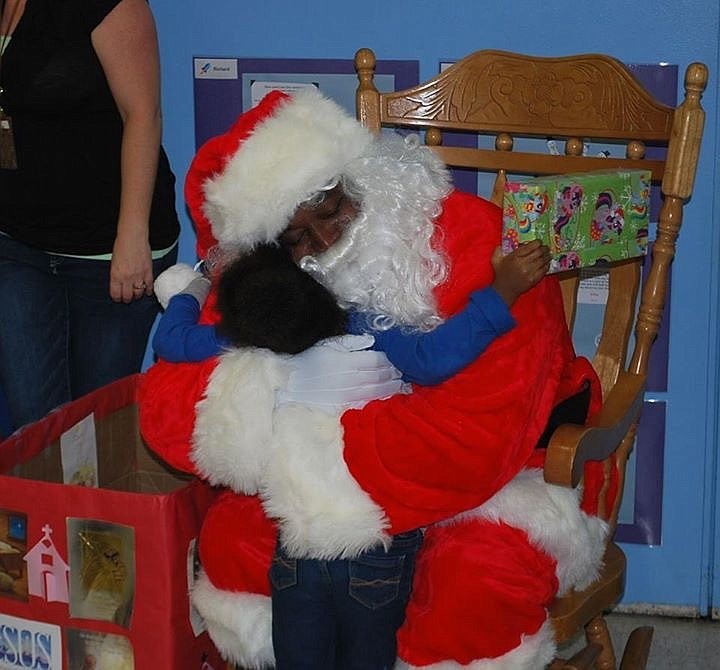 A Daytona Beach fire fighter hugs a child during the Christmas toy drive. Photo courtesy of First Baptist Church Daytona