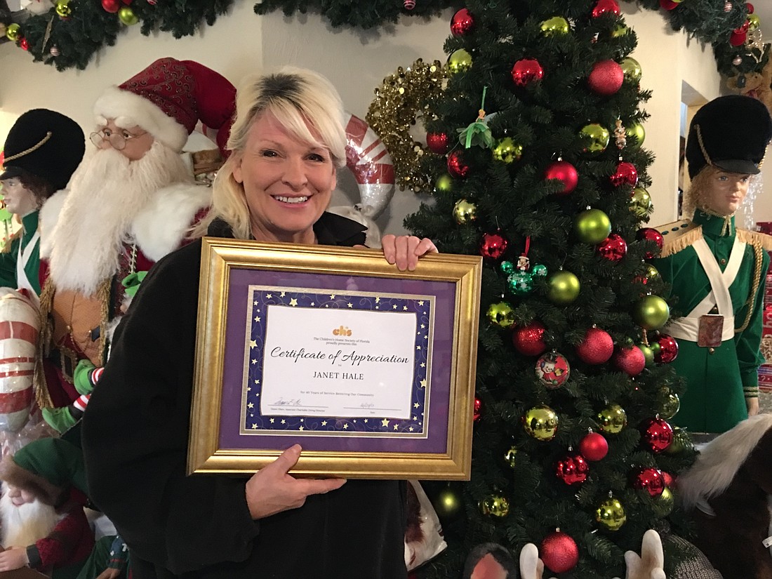 Janet Hale holds here plaque from the Children's Home Society of Florida. Photo by Nichole Osinski