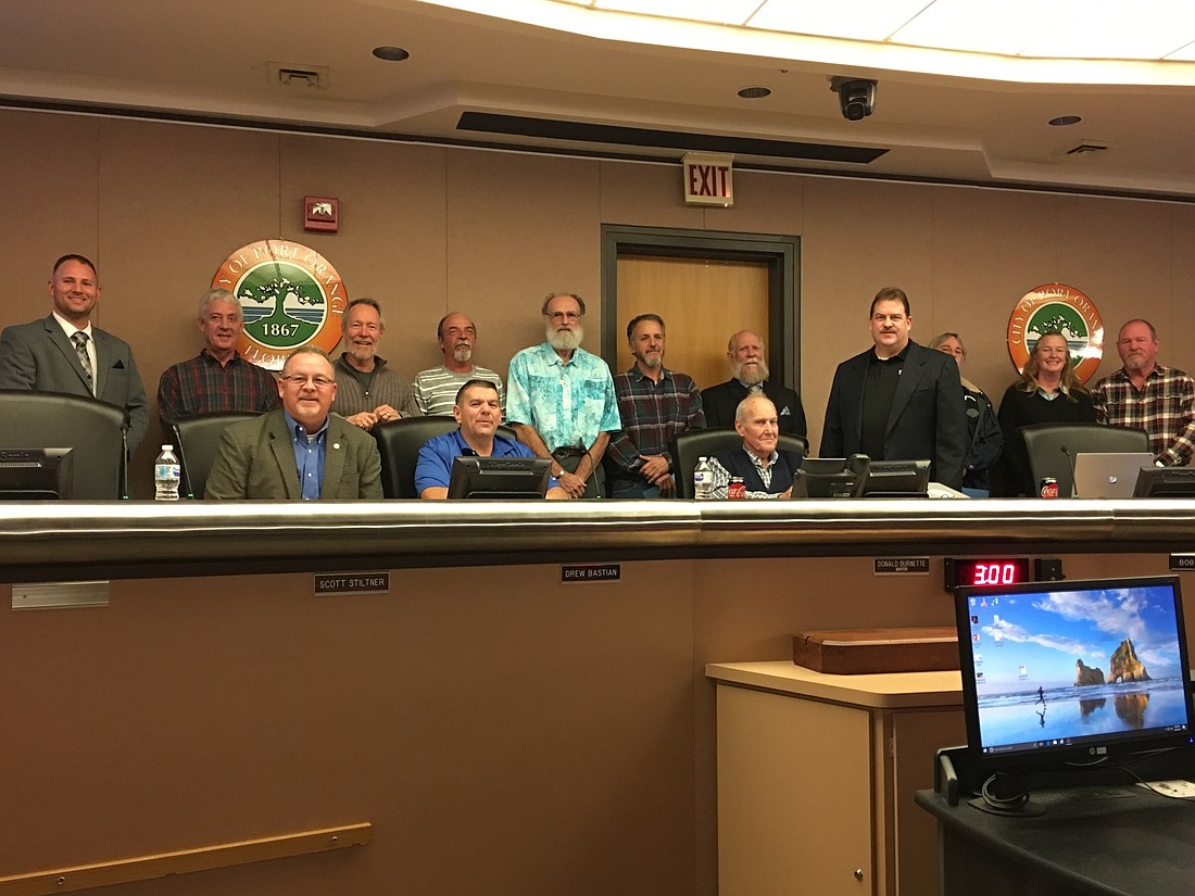 The city council poses for a photo with several retired city employees. Photo by Nichole Osinski