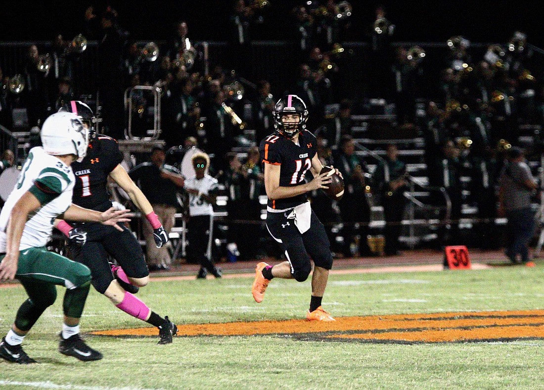 Spruce Creek quarterback Kyle Minckler rolls out of the pocket against FPC. Photo by Ray Boone