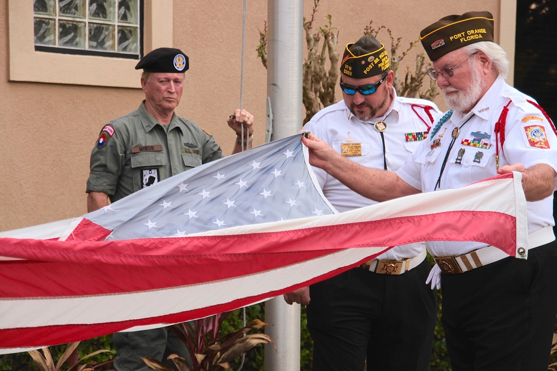 Jimmie Adams and Mike Wright fold the American flag. Photo by Nichole Osinski