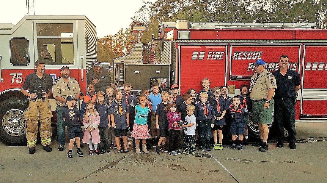 Lt. Philip Callea, Assistant David Carson, Engineer Fireman Warren Faulkner, Scout Master Wayne Kelly and Paramedic Joe Lalond stand with Cub Scouts and their families. Photo courtesy of the Knights of Columbus