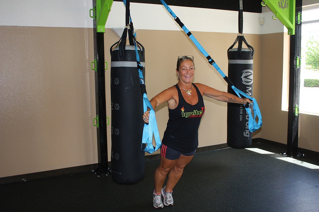 Joanne Buzzone of Ignite Fitness II demonstrates TRX, a suspension training system. Photo by Wayne Grant