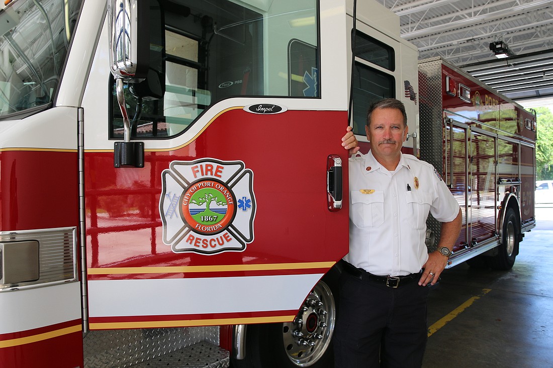 Port Orange Fire Chief Ken Fustin stands besides a fire engine. Photo by Jarleene Almenas