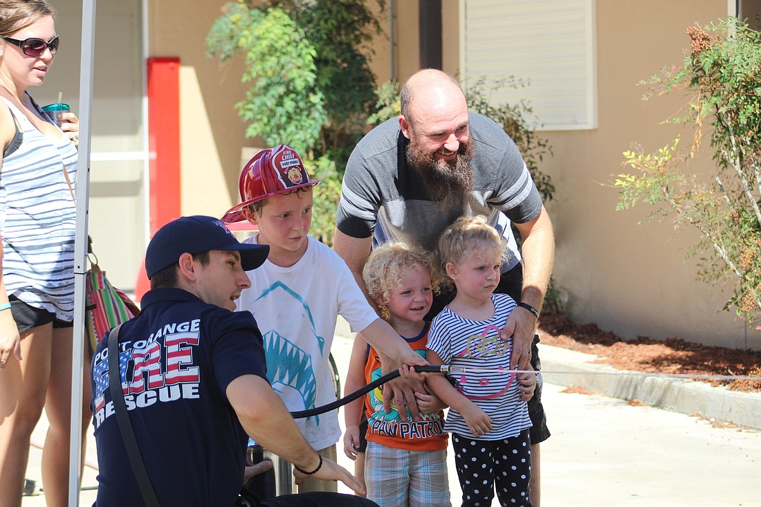 Firefighter Andy Kurila teaches children how to put out a house fire with the Fire Safety Simulator. Photos by Lurvin Fernandez.