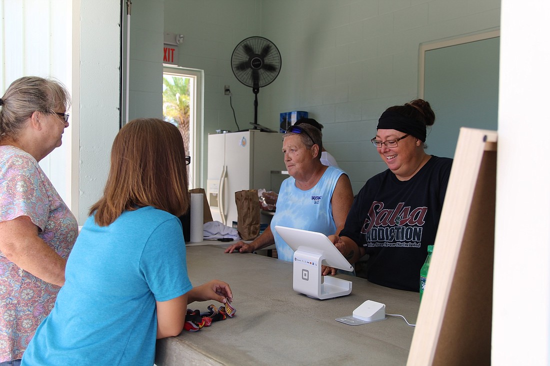 Judy Capell and Maria Mills-Benat serve customers at Riverwalk Park. Photos by Lurvin Fernandez