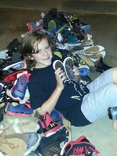 Matthew Monroe with the 162 pairs of shoes he collected (Courtesy photo).