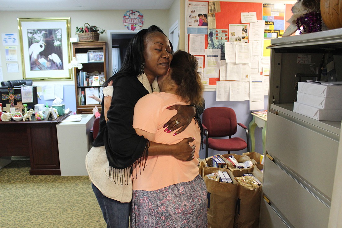 Vee'tina Malone embraces volunteer Leah Vanvorst while she grieves the recent loss of a close friend (Photo by Emily Blackwood)