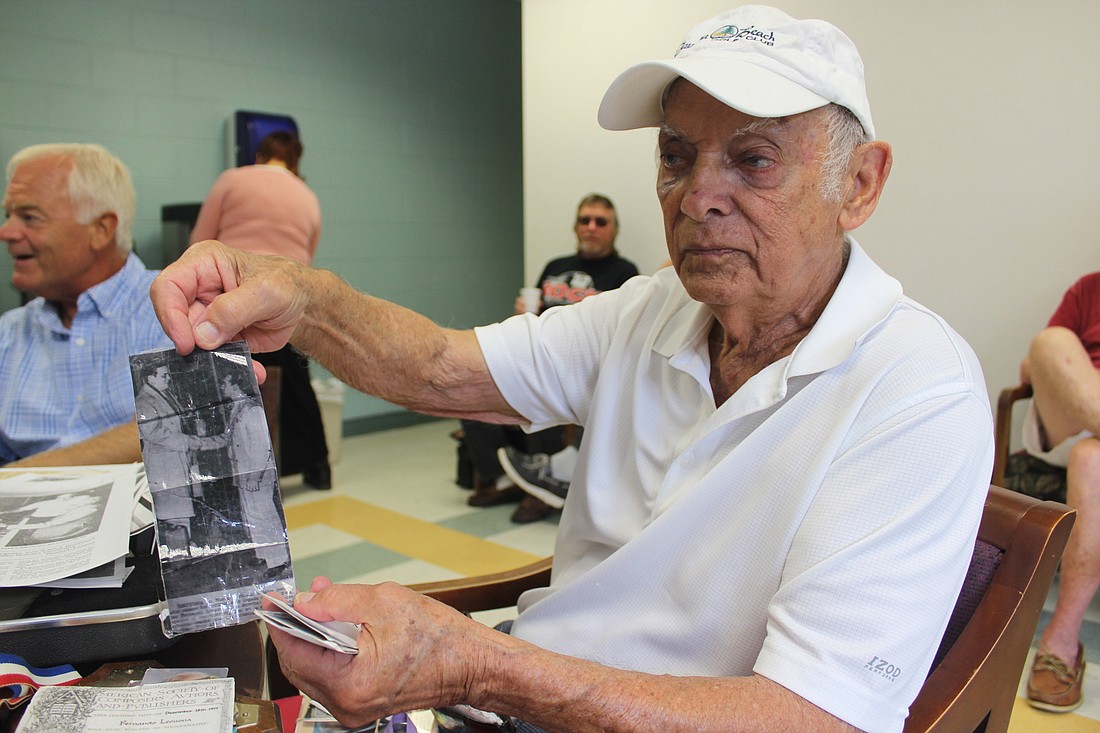 Fernando Lecuona, 89, showing one of the many newspaper clippings he's saved to document his accomplishments (Photo by Emily Blackwood).
