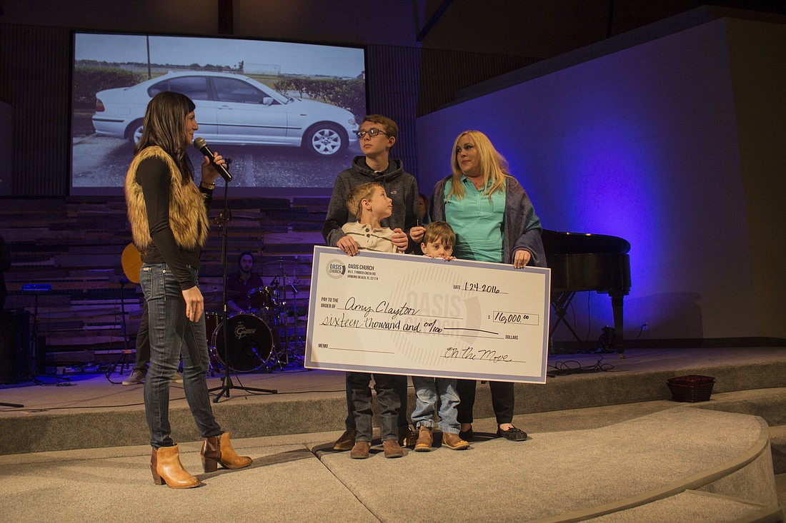 Meagan Scharmahorn presents a $16,000 to Amy Clayton and her boys (Photo by Emily Blackwood).