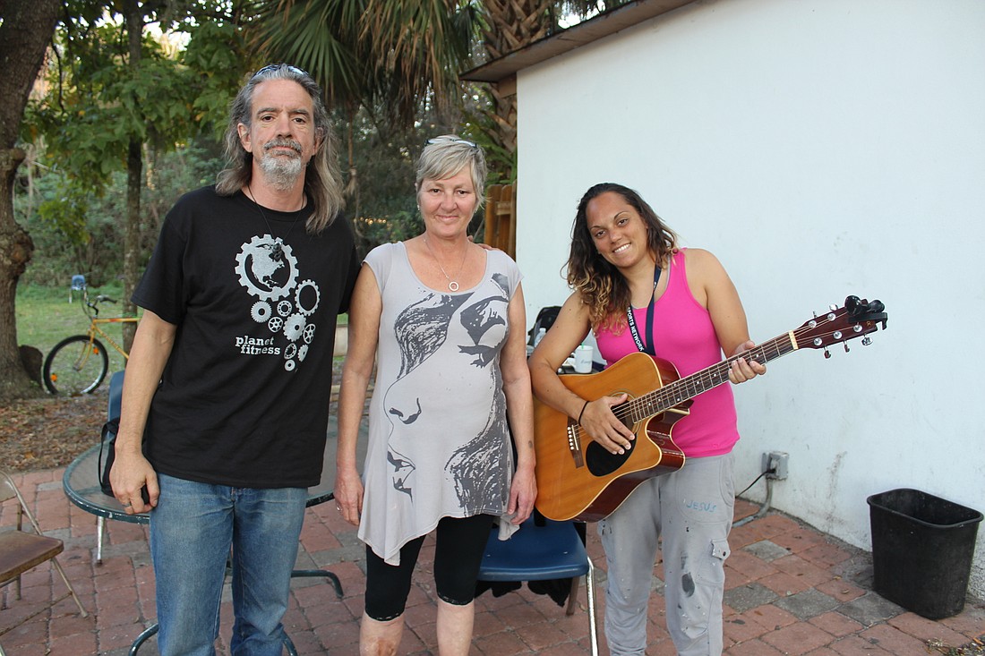 Shayne Chandronnet, Tammy Sandrowicz and Hayley Gibson gather for some music and company at Ormond Beach Alliance Church â€” where they are all currently staying. Gibson said "radical restoration happens here" (Photo by Emily Blackwood).