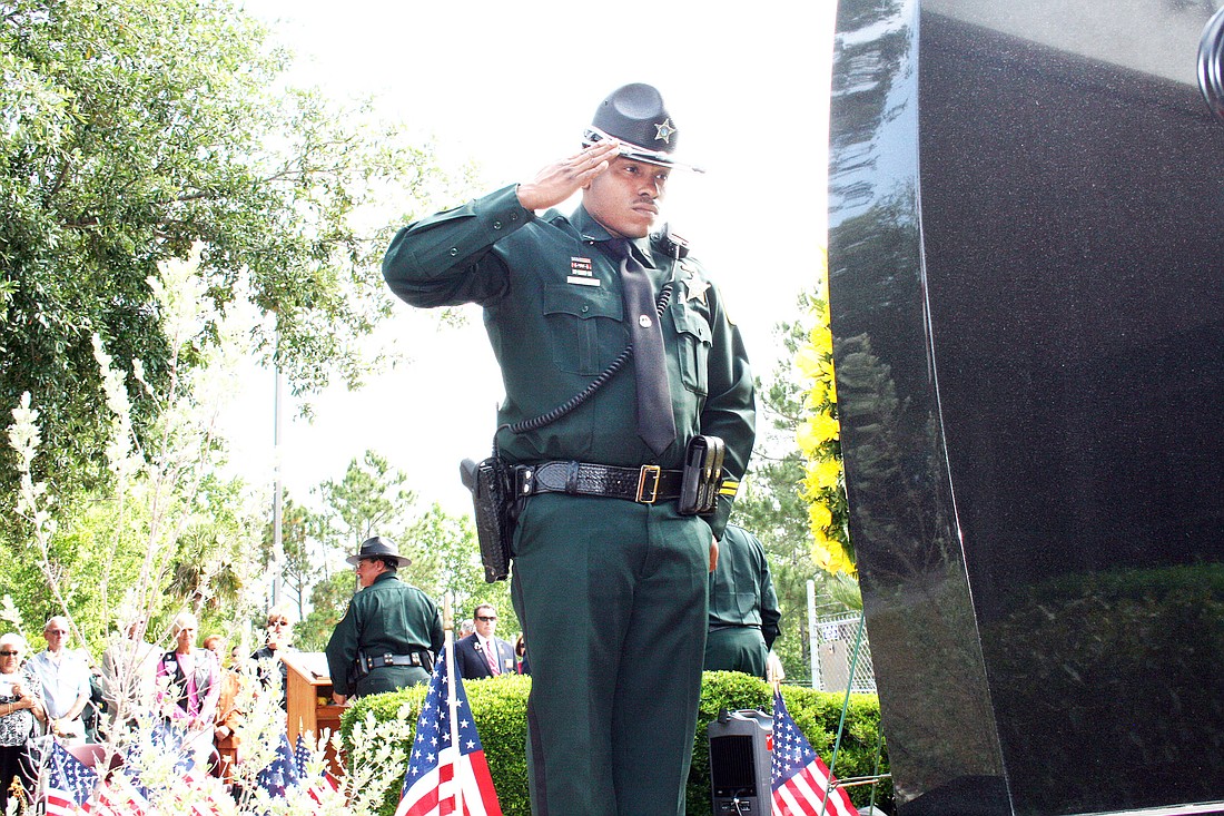 Deputy Julio Vazquez salutes the monument May 12, at the Flagler County SheriffÃ¢â‚¬â„¢s Office, in honor of law enforcement officers who have died in on duty. PHOTO BY BRIAN MCMILLAN