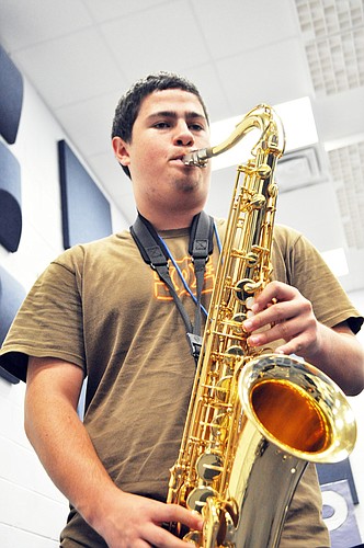 Chad Wilkinson wails on the saxophone during rehearsal in the MHS band room. PHOTOS BY SHANNA FORTIER