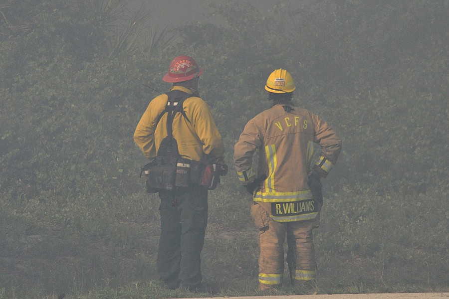 Firefighters look through the smoke last week at the fire along Highway U.S. 1, in Korona. SHANNA FORTIER