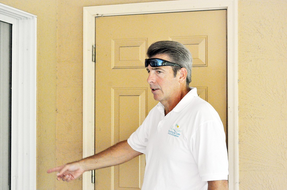 Code Enforcement Officer Bruce MacDonald examines a vacant home July 11 in the R-section, in Palm Coast. PHOTO BY ANDREW O'BRIEN