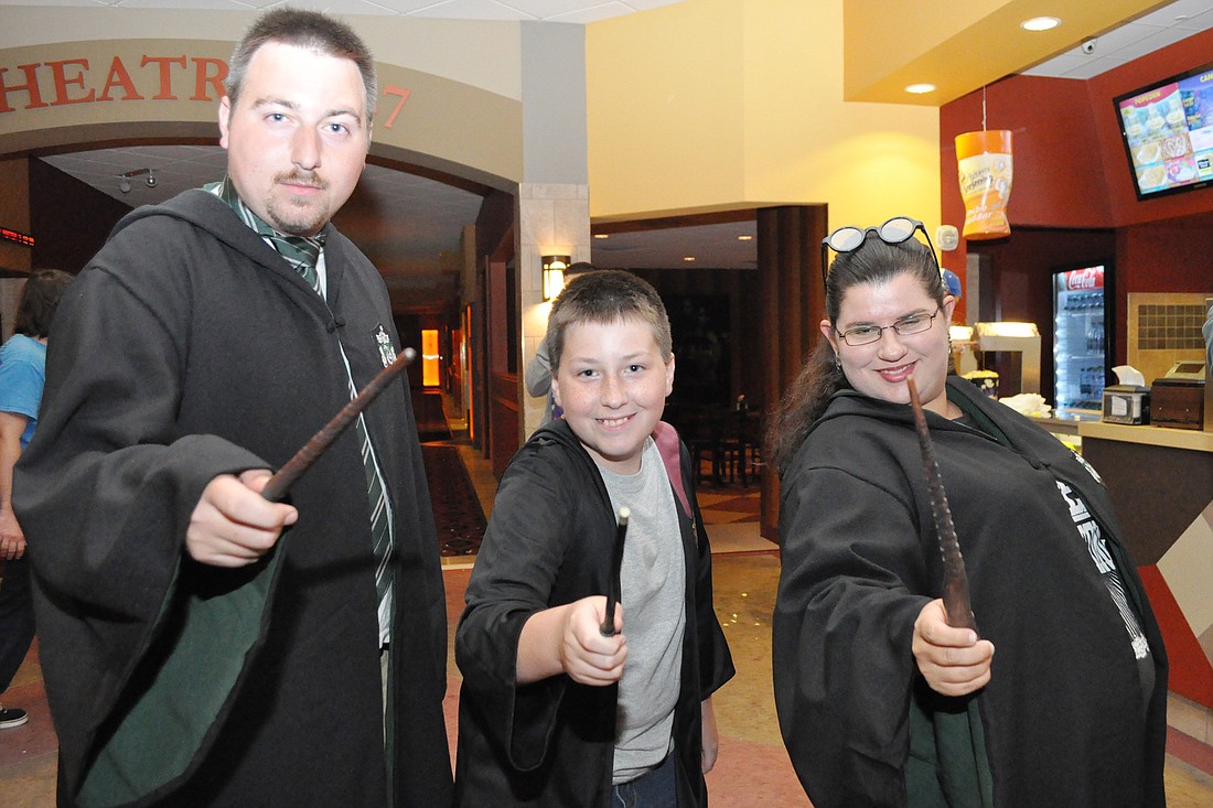 Joshua Adkins (Slytherin), Danieal Adkins (Gryffindor) and Crystal Rodriguez (Slytherin), show off their wand techniques at the midnight Harry Potter showing.