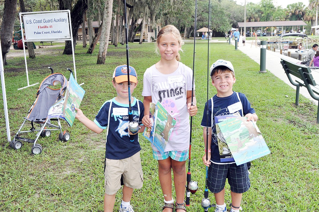 James, Megan and Shawn Mercready show off their free fishing poles. PHOTOS BY SHANNA FORTIER
