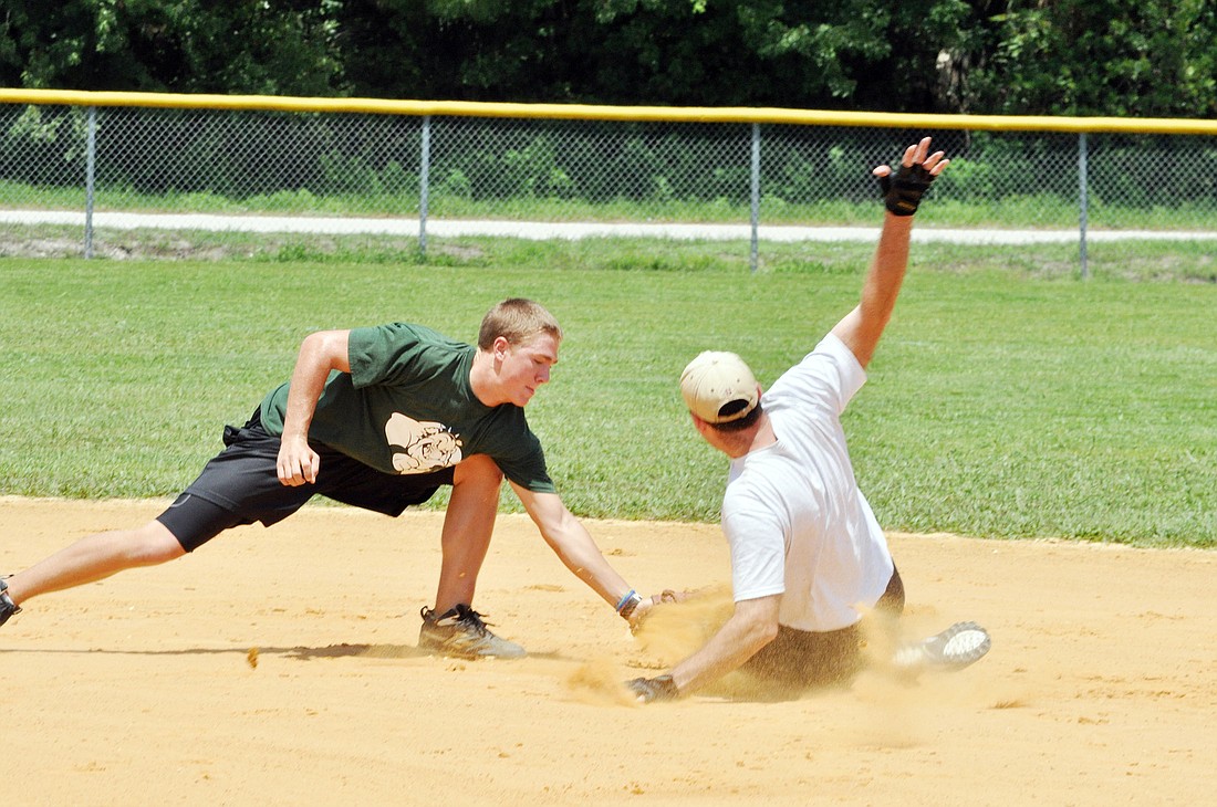 Joe OÃ¢â‚¬â„¢Brien, shortstop for Fox Landscaping, tags out Rod Long, of Flagler Coed, at second base. PHOTOS BY SHANNA FORTIER