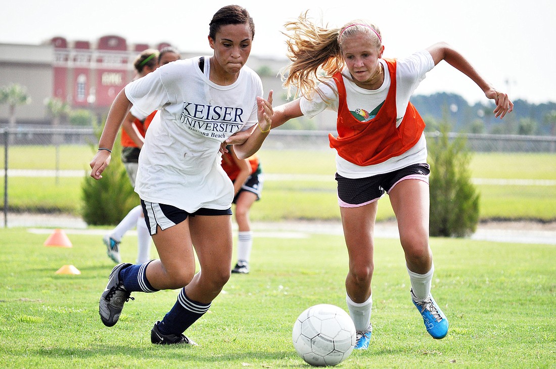 Chasity Vigo and Cara Warren battle for the ball during a one-on-one drill Tuesday morning at the Go To Goal soccer camp.
