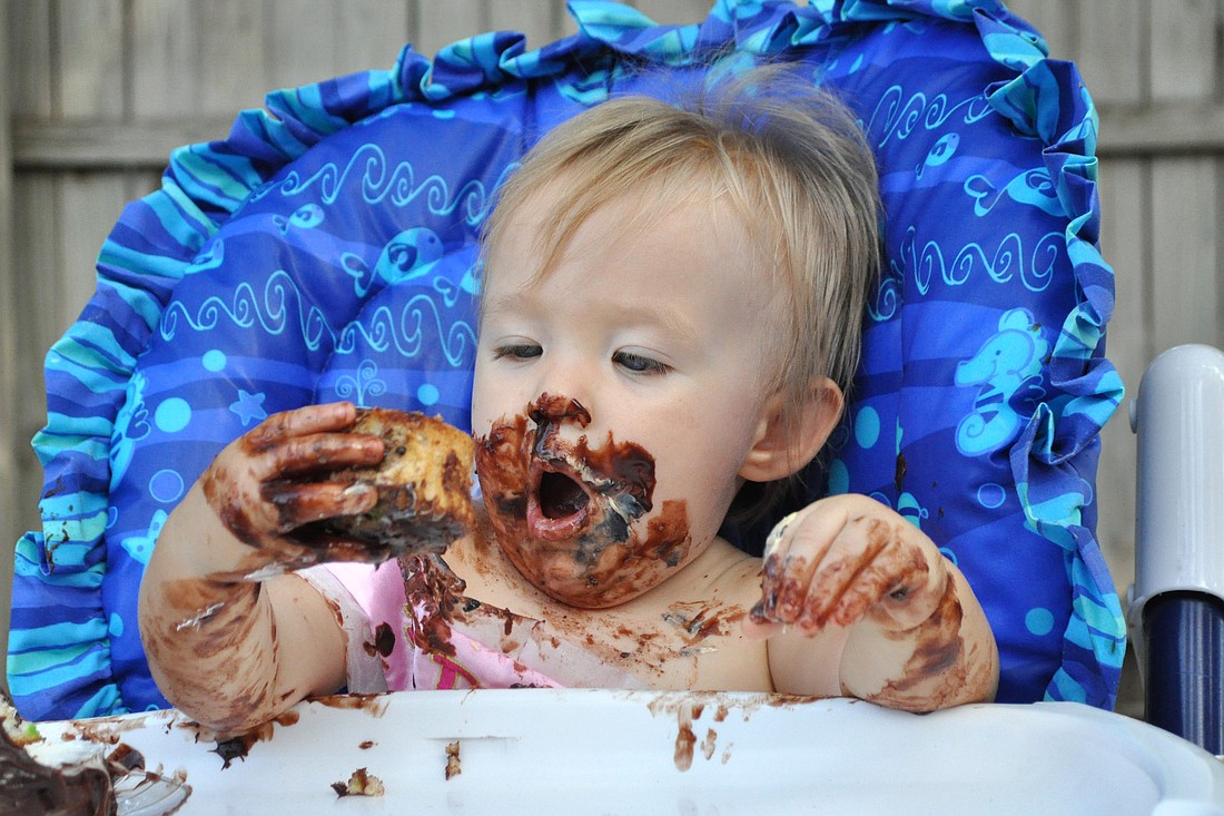 Jocelyn Phillips enjoys a monkey cupcake on her first birthday.