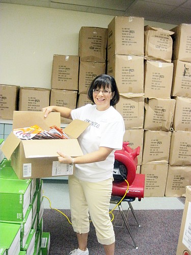 Linda Mahan, of the United Way Flagler WomenÃ¢â‚¬â„¢s Initiative, was one of several volunteers who stuffed backpacks for the Flagler Education Foundation Packs for Backs event. COURTESY PHOTO