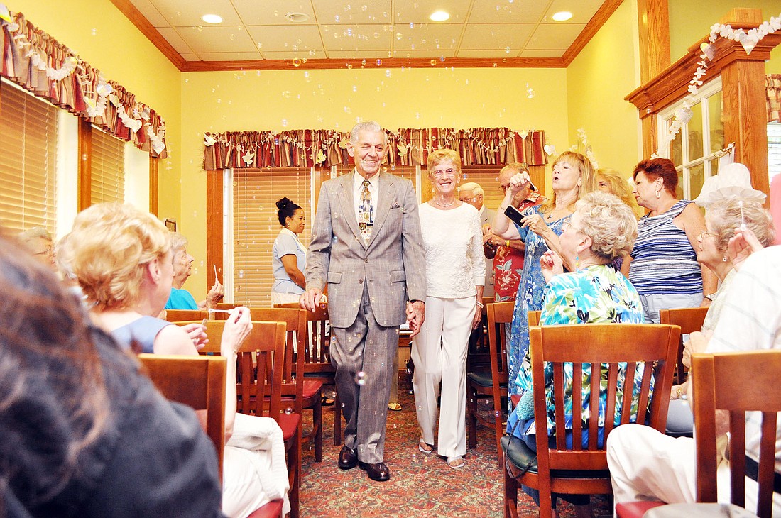 Newlyweds Ed and Thelma Poliak walk down the aisle for the first time as a married couple.