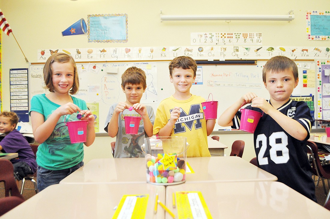 Second-grade students Harley Advox, Jesse Doolin, Trevor Stone and Brett Kropp show off their individual buckets. PHOTOS BY SHANNA FORTIER
