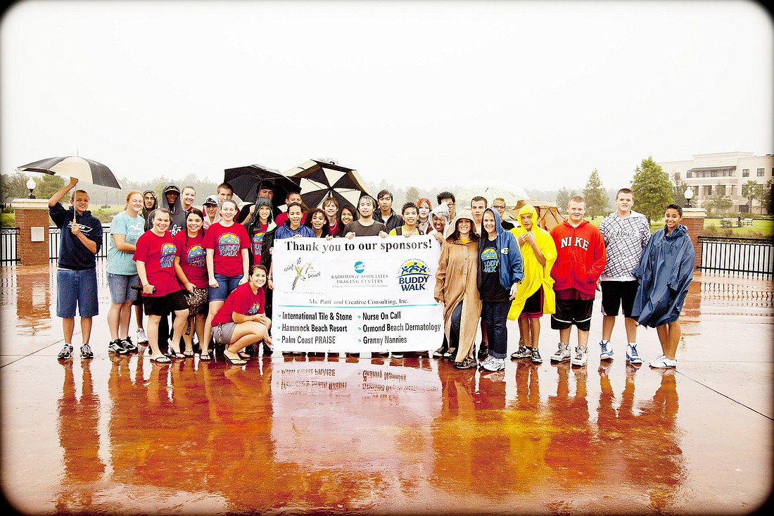 A group of volunteers worked through the rain to set up the Buddy Walk before having to stop due to unsafe conditions. COURTESY PHOTOS