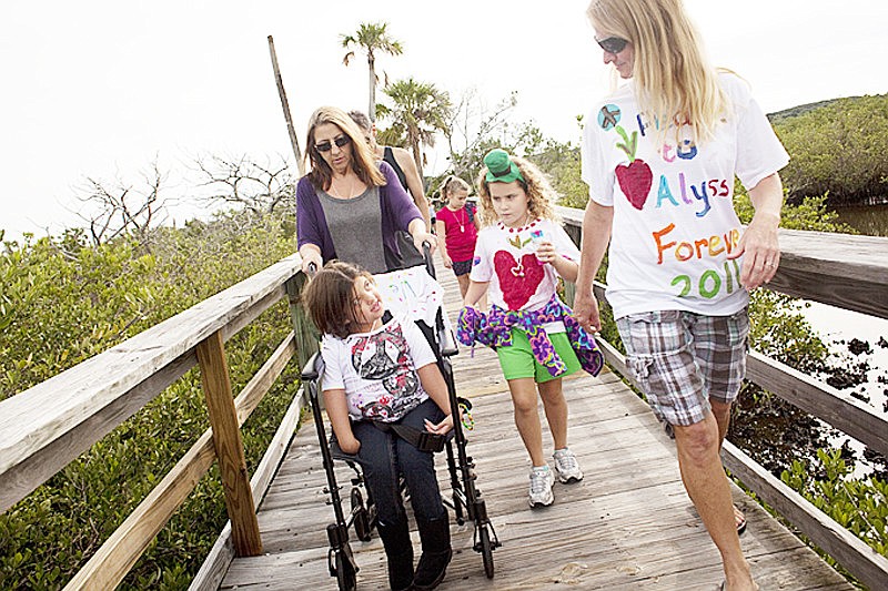 Dale Brooke pushes her granddaughter, Alyssa Hagstrom, on the walk with Karina Bell and Kerri Huckabee, director and owner of the Flagler Beach Montessori School. COURTESY PHOTO