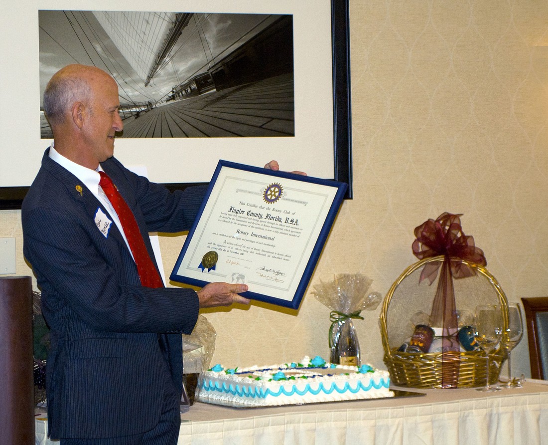 Club President Bill Butler holds the original Club Charter.
