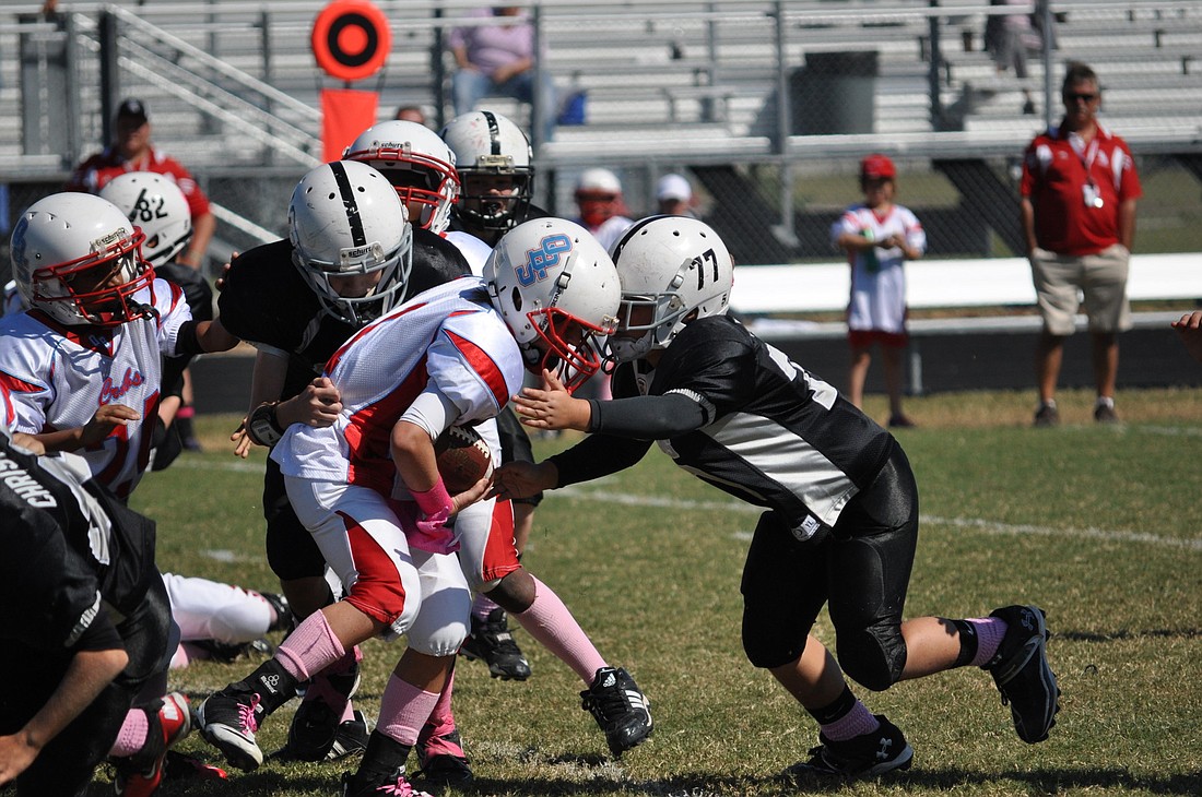 Riley Furtado (77) makes a tackle earlier in the season during an East Coast Conference game. The Falcons' defense has helped lead the way this season.