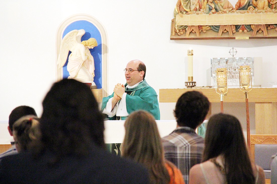 The Rev. Alberto Esposito blesses the Holy Communion. PHOTOS BY SHANNA FORTIER