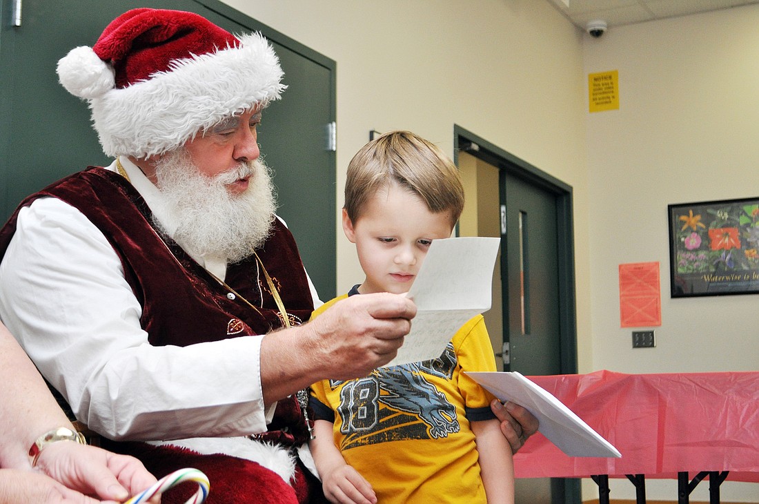 Santa reads a letter that was written to him by Lucas Price, 4. PHOTOS BY SHANNA FORTIER