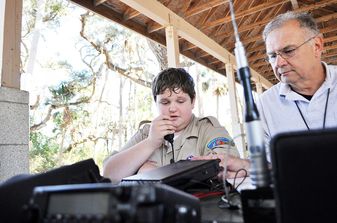 Boy Scout Jake Dotson talks to Fort Campbell with the help of John Woika, call sign W8JW. PHOTOS BY SHANNA FORTIER
