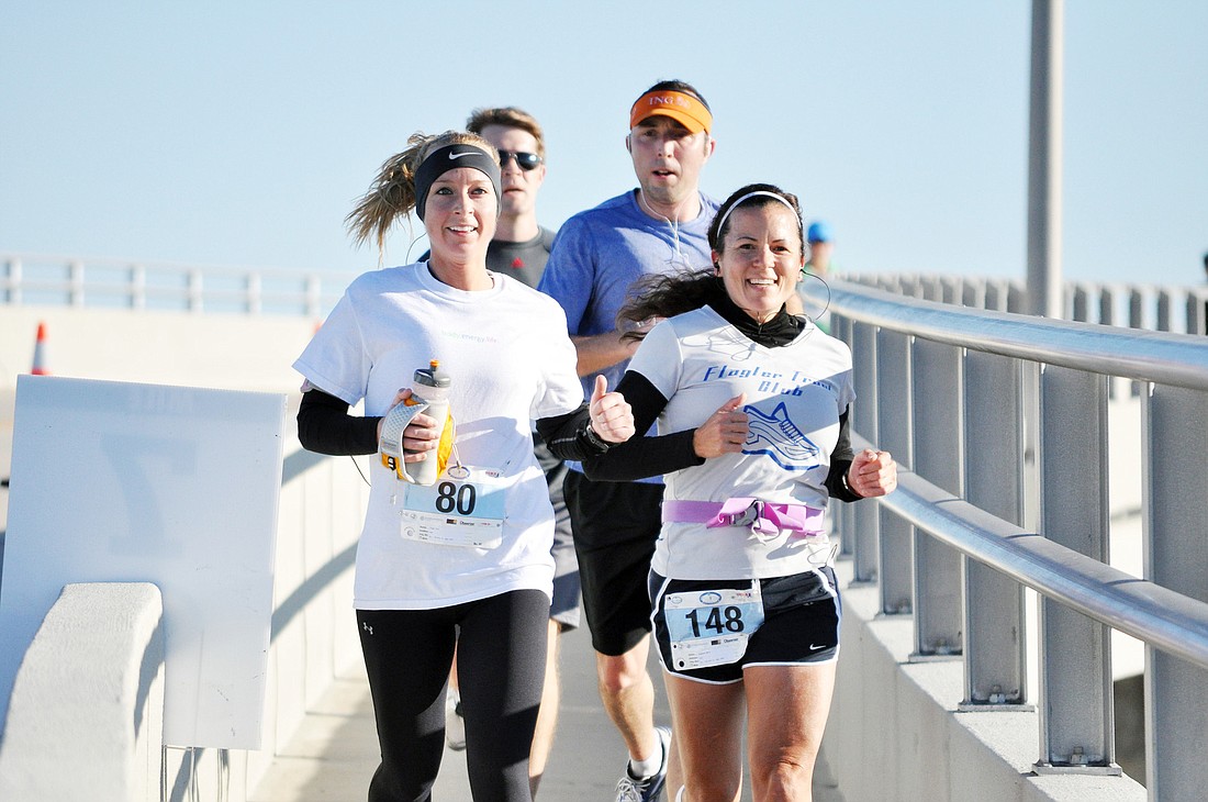 Amy Higgs and Maria Pugliese cross the Hammock Dunes Bridge at the seven-mile mark during SundayÃ¢â‚¬â„¢s half marathon.