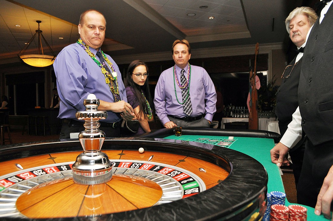 Ray Savidge takes on the roulette table, with onlookers Marci Savidge and Rich Savidge.