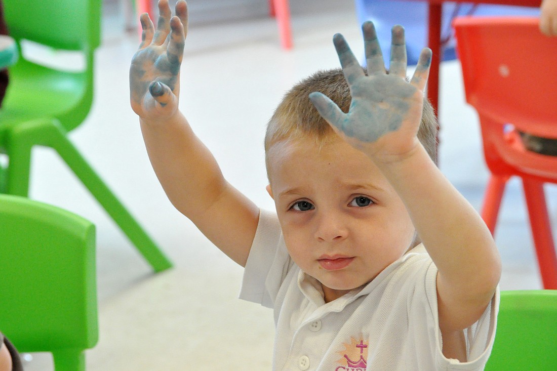 Nicky Yacono shows off his paint-covered hands during craft time at Christ the King's 2011 vacation Bible school.